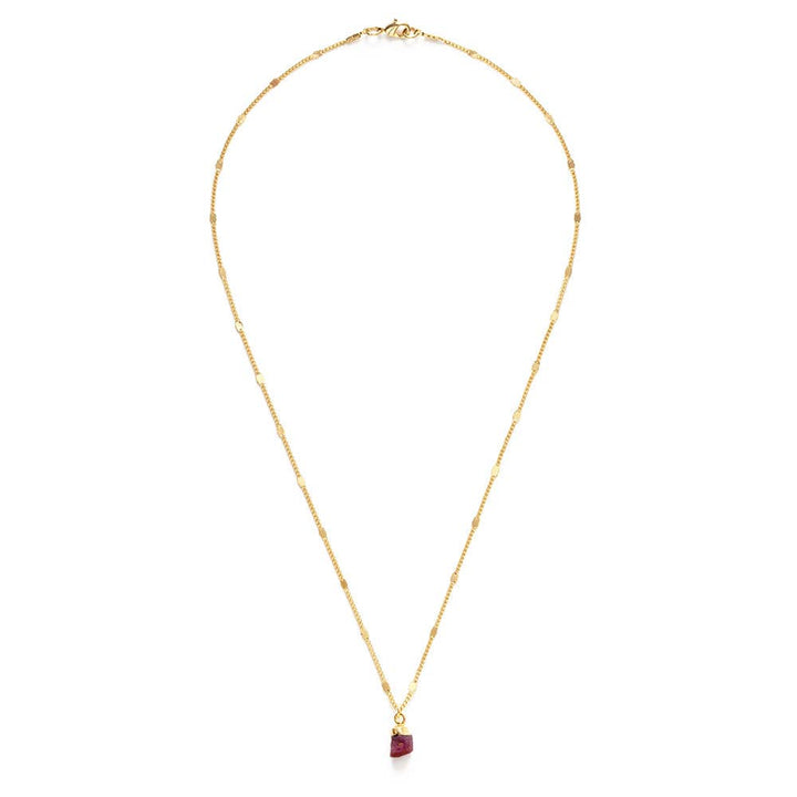 Gold necklace with a red gemstone pendant on a white background