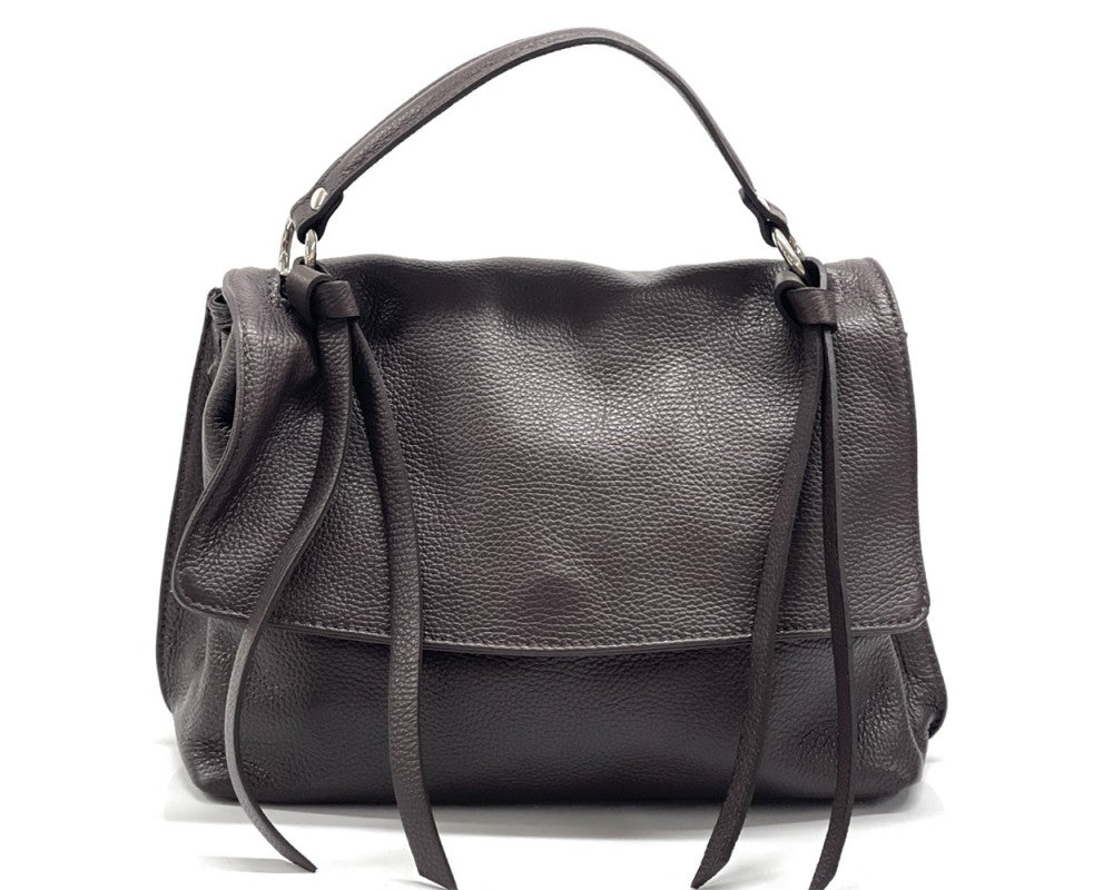 A dark brown pebbled leather handbag with a top handle and long hanging ties, photographed against a plain white background.