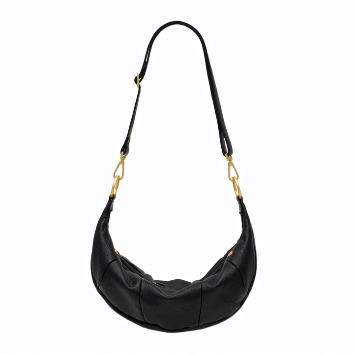 A black crescent-shaped leather shoulder bag with gold-tone hardware and a long adjustable strap, shown against a plain white background.