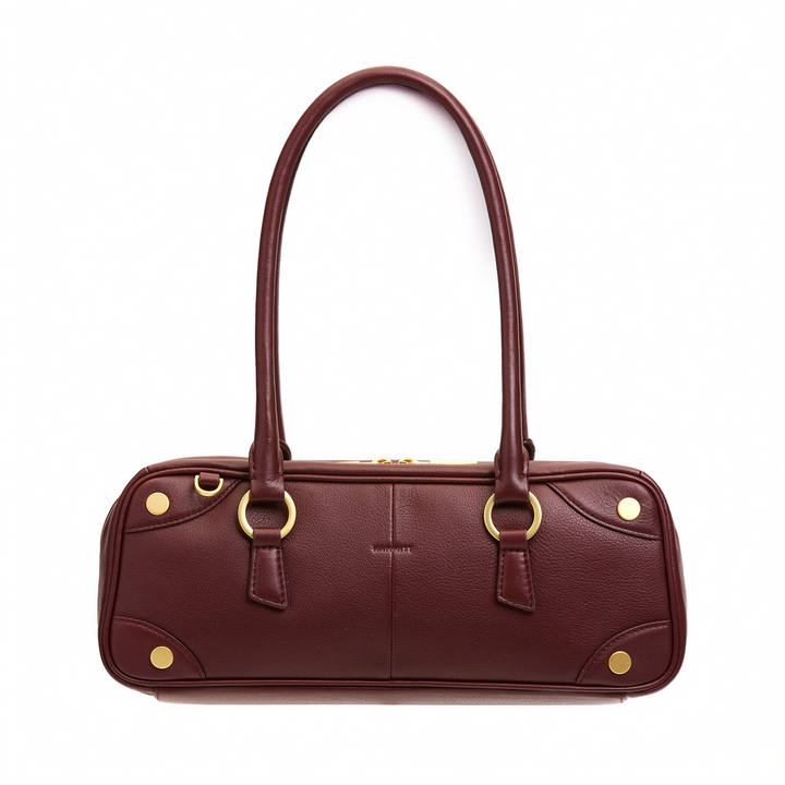 A burgundy pebbled leather handbag with gold-tone hardware, featuring dual top handles, a structured oval body, and decorative gold rivets on a plain white background.