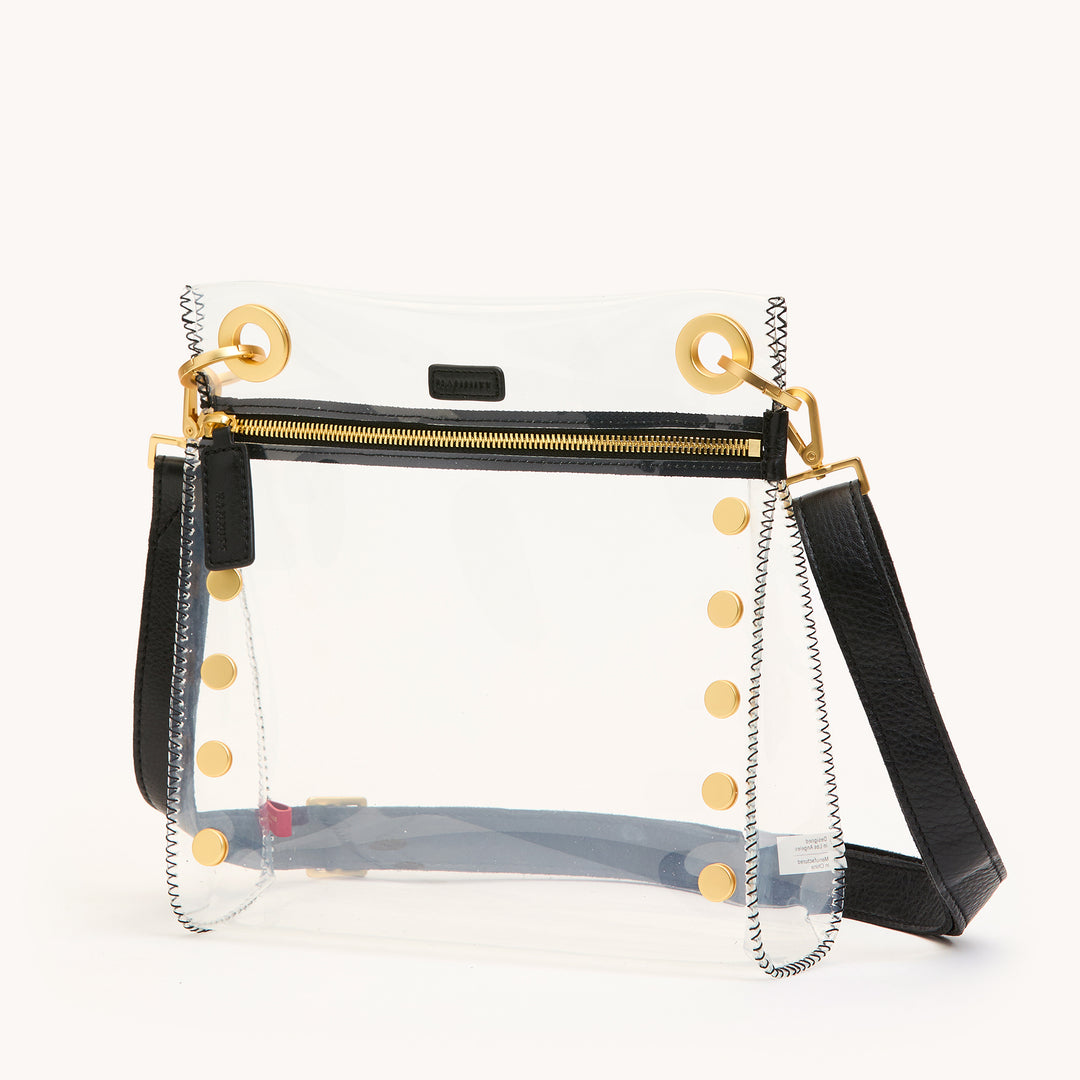 Clear handbag with black accents and gold buttons on a white background | Artisans