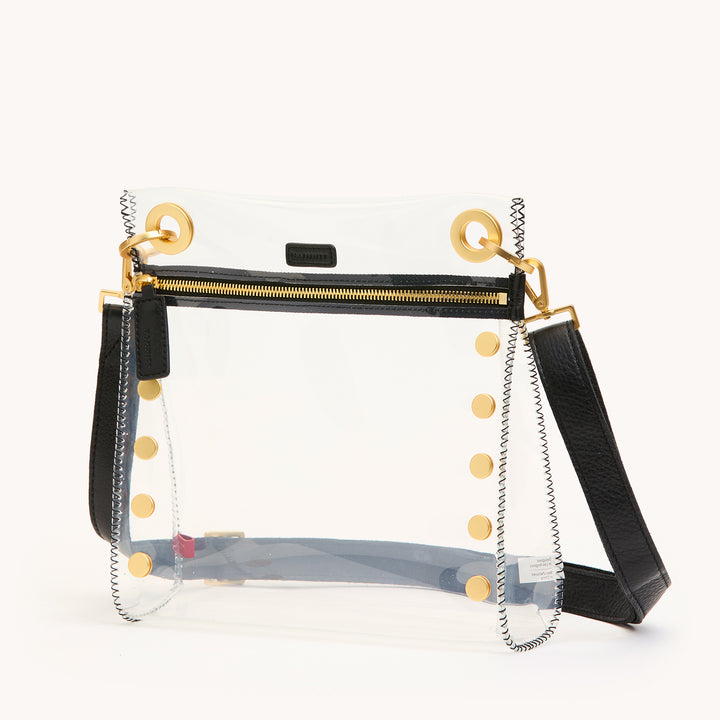 Clear handbag with black accents and gold buttons on a white background | Artisans