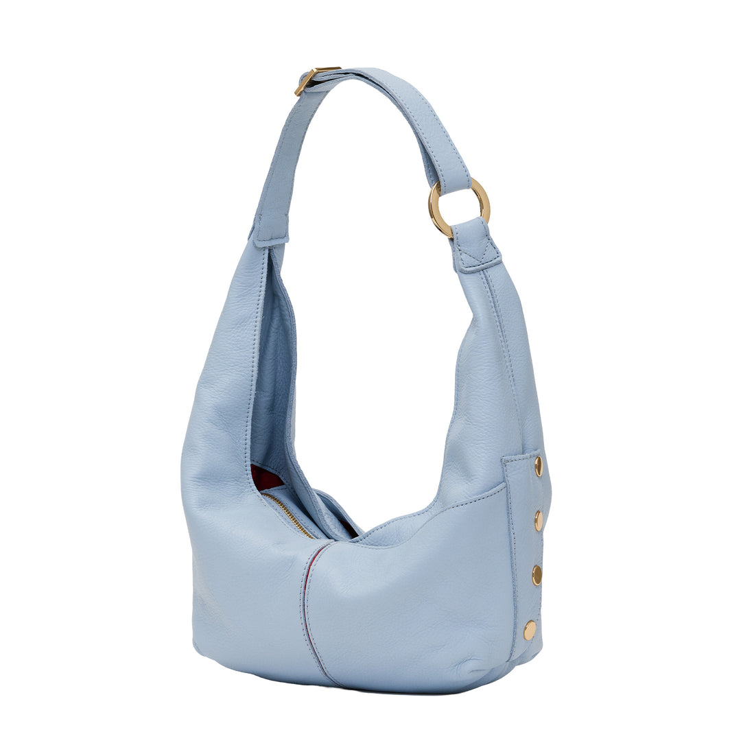 A light blue pebbled leather hobo shoulder bag with gold-tone hardware, including a ring on the strap and decorative studs on the side, shown against a plain white background.