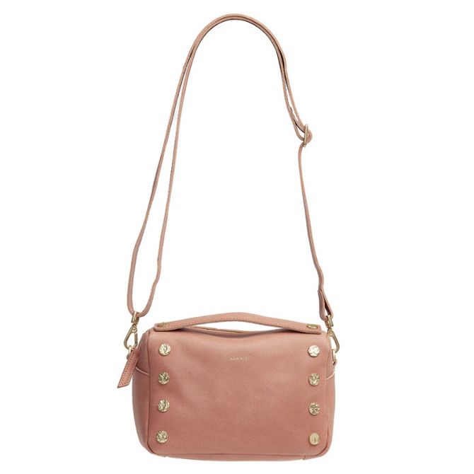 A dusty pink leather crossbody bag with a top handle, a long adjustable shoulder strap, and decorative gold-tone studs on the front, shown against a plain white background.