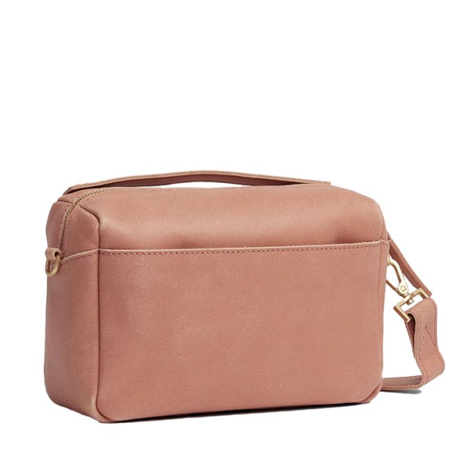 A dusty rose pink faux leather cosmetic bag with a top handle, zippered closure, and a detachable shoulder strap with gold-tone hardware, shown on a plain white background.